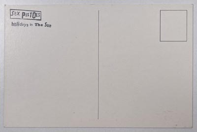 Lot 114 - THE SEX PISTOLS - HOLIDAYS IN THE SUN - ORIGINAL POSTCARD AND STICKER.