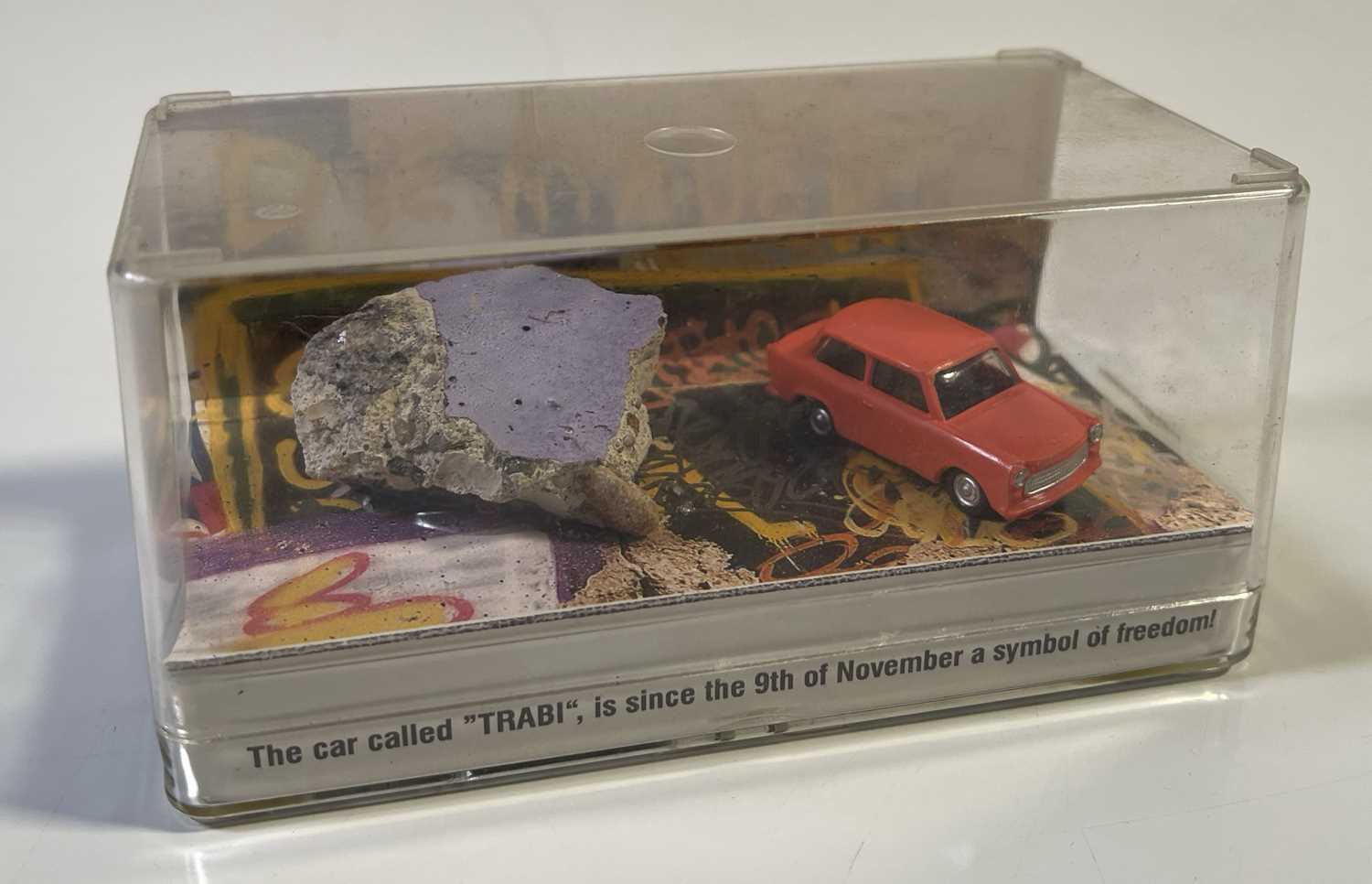 Lot 265 - U2 ACHTUNG BABY - PIECE OF BERLIN WALL IN TRABANT DISPLAY.